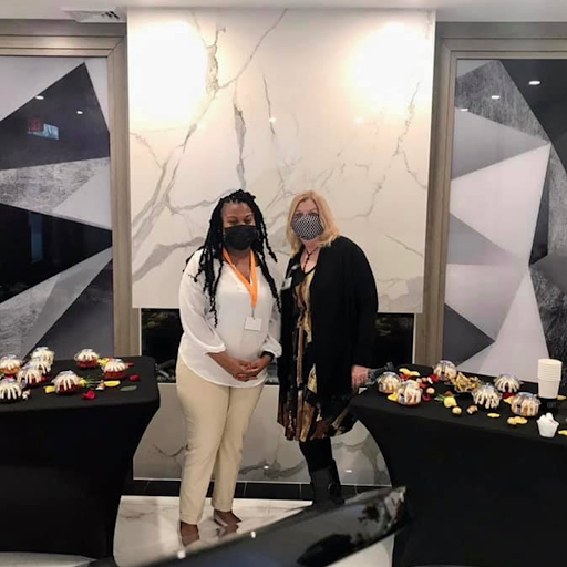 Two women posing together at an elegantly decorated event.