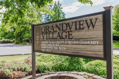 Sign for Grandview Village retirement community surrounded by greenery.