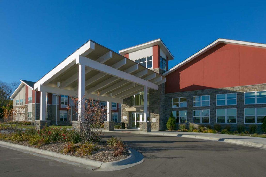 A modern building with a covered entrance on a clear day.