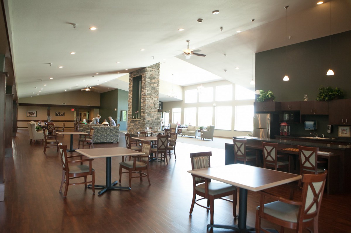 A spacious restaurant interior with tables and chairs arranged in a well-lit dining area.