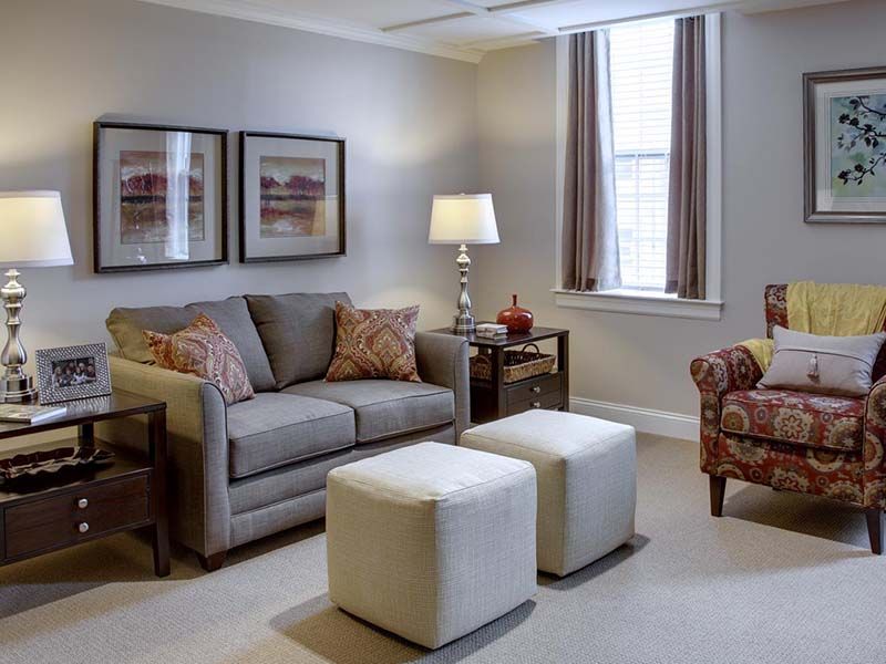A cozy living room with a sofa, armchair, and modern decor.