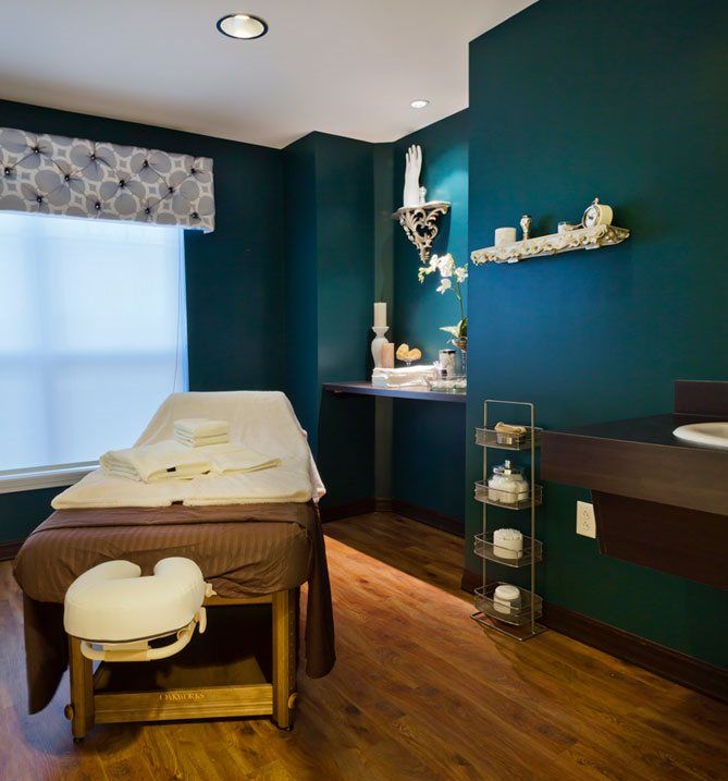 A serene spa room with a massage table and calming decor.