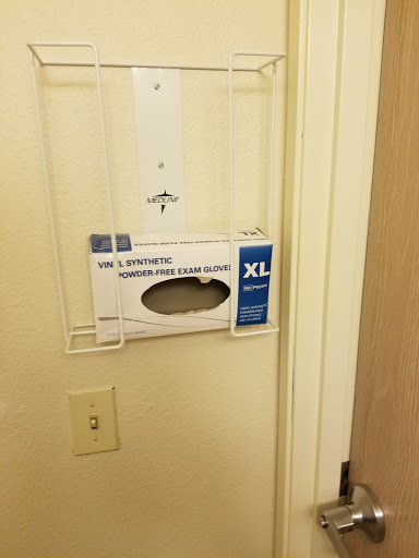 A wall-mounted dispenser holding XL gloves for hygienic use.