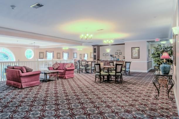 A spacious lounge area with decorative carpet, comfortable seating, and ambient lighting.