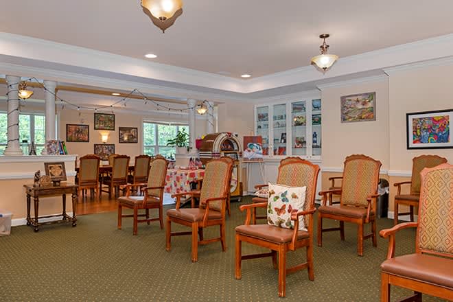 A cozy interior space featuring wooden chairs and a dining area.