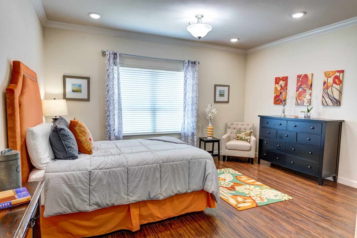 A contemporary styled bedroom with a neatly made bed, modern furniture, and elegant decor.