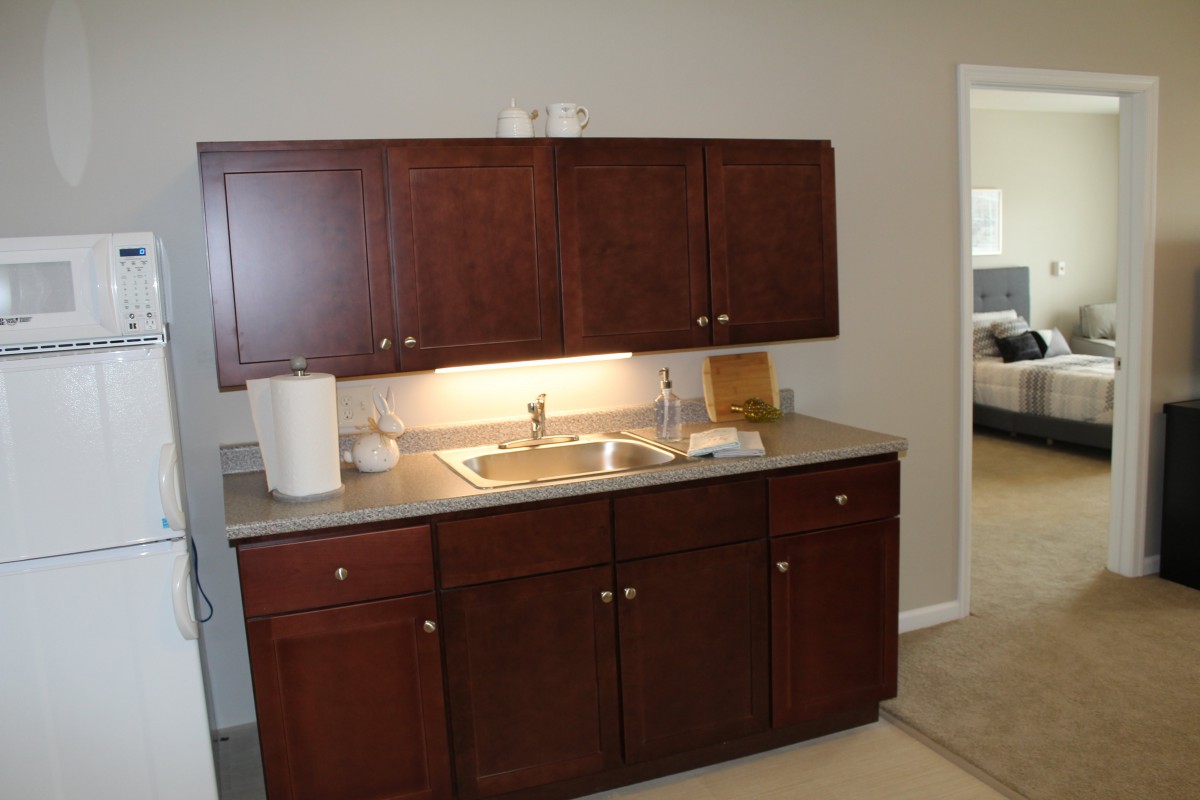 A compact kitchen setup with wooden cabinets and a sink.
