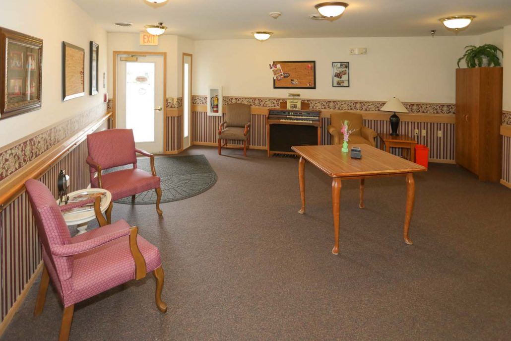 A cozy room with seating and a wooden table, featuring soft lighting and decorative elements.