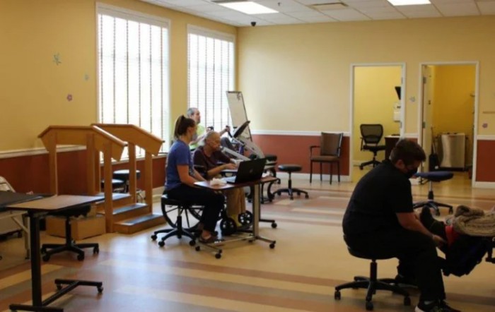 A physical therapy clinic with patients and therapists during a session.