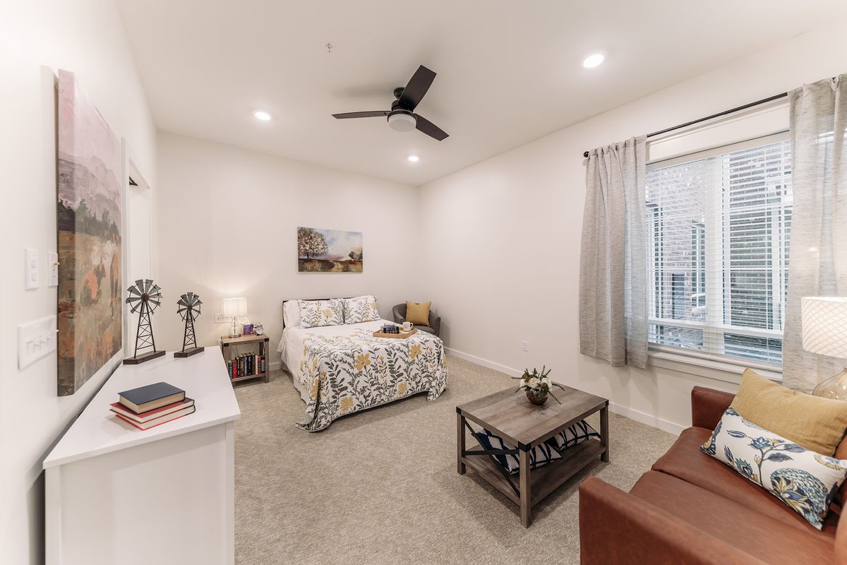 A modern, well-decorated bedroom with a bed, side tables, and comfortable furniture.