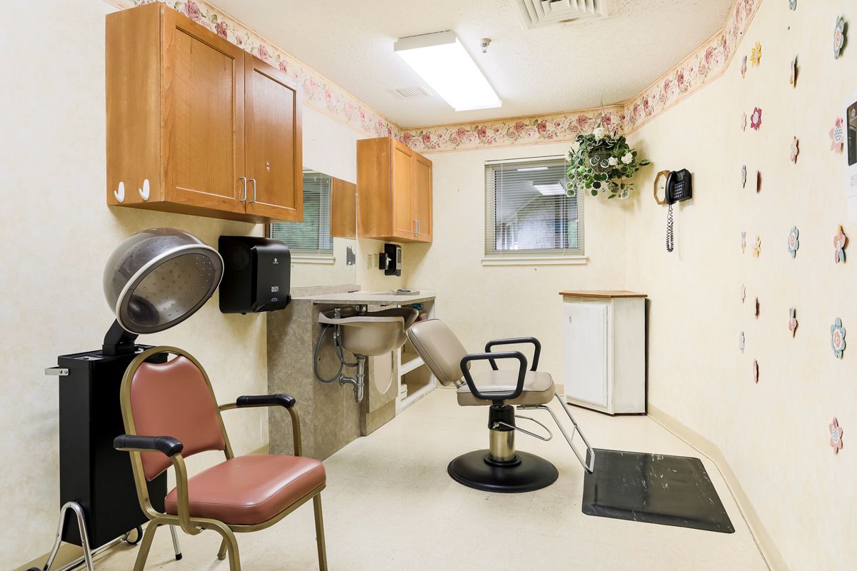 A small hair salon with chairs, a sink, and a hair dryer.