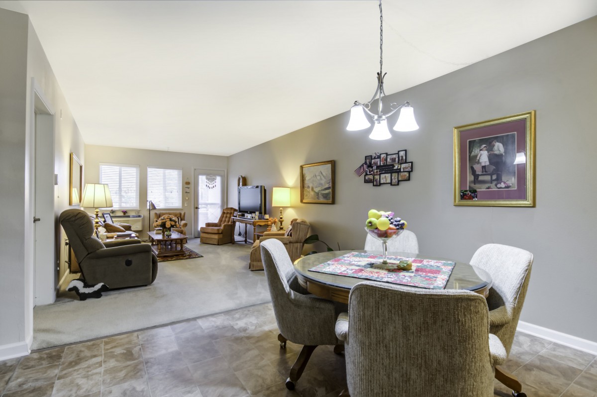 A cozy living and dining area with comfortable seating, a television, and decorative artwork.