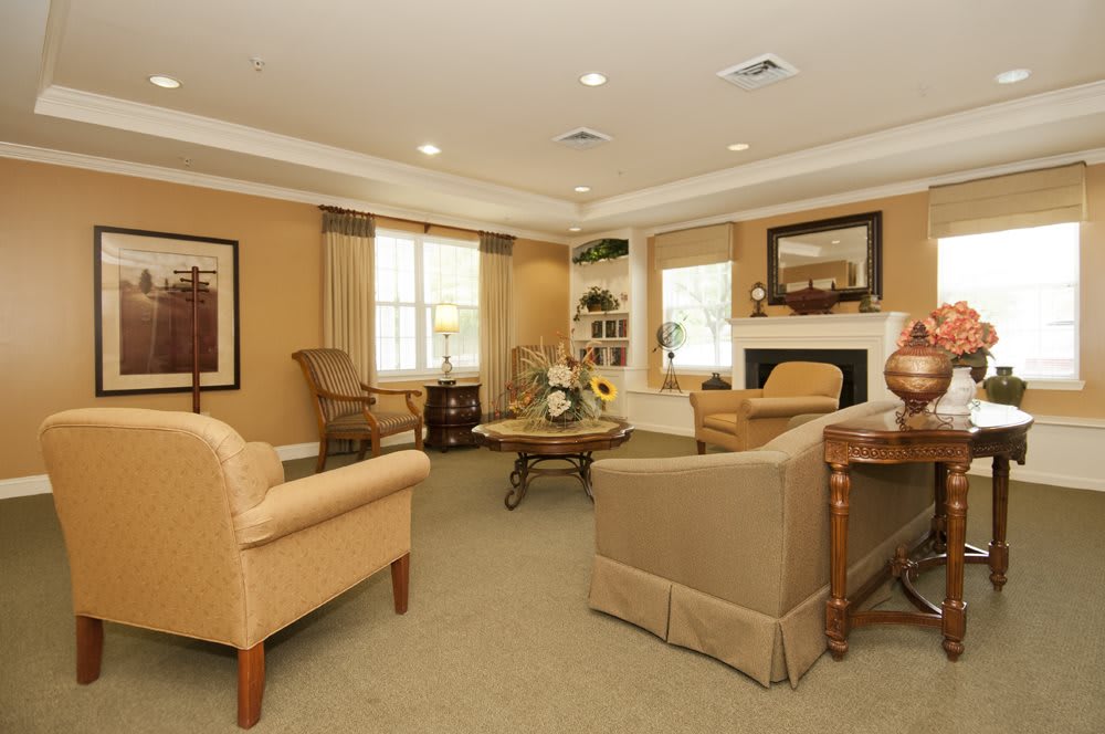 A cozy living room with beige furniture, a fireplace, and warm lighting.