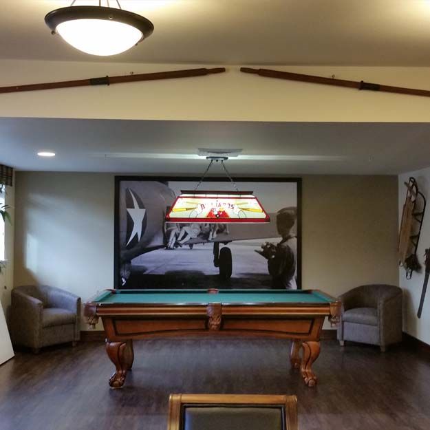 A cozy game room featuring a pool table, wall art, and seating area.
