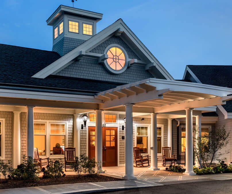 A well-lit house with a welcoming porch during the evening.