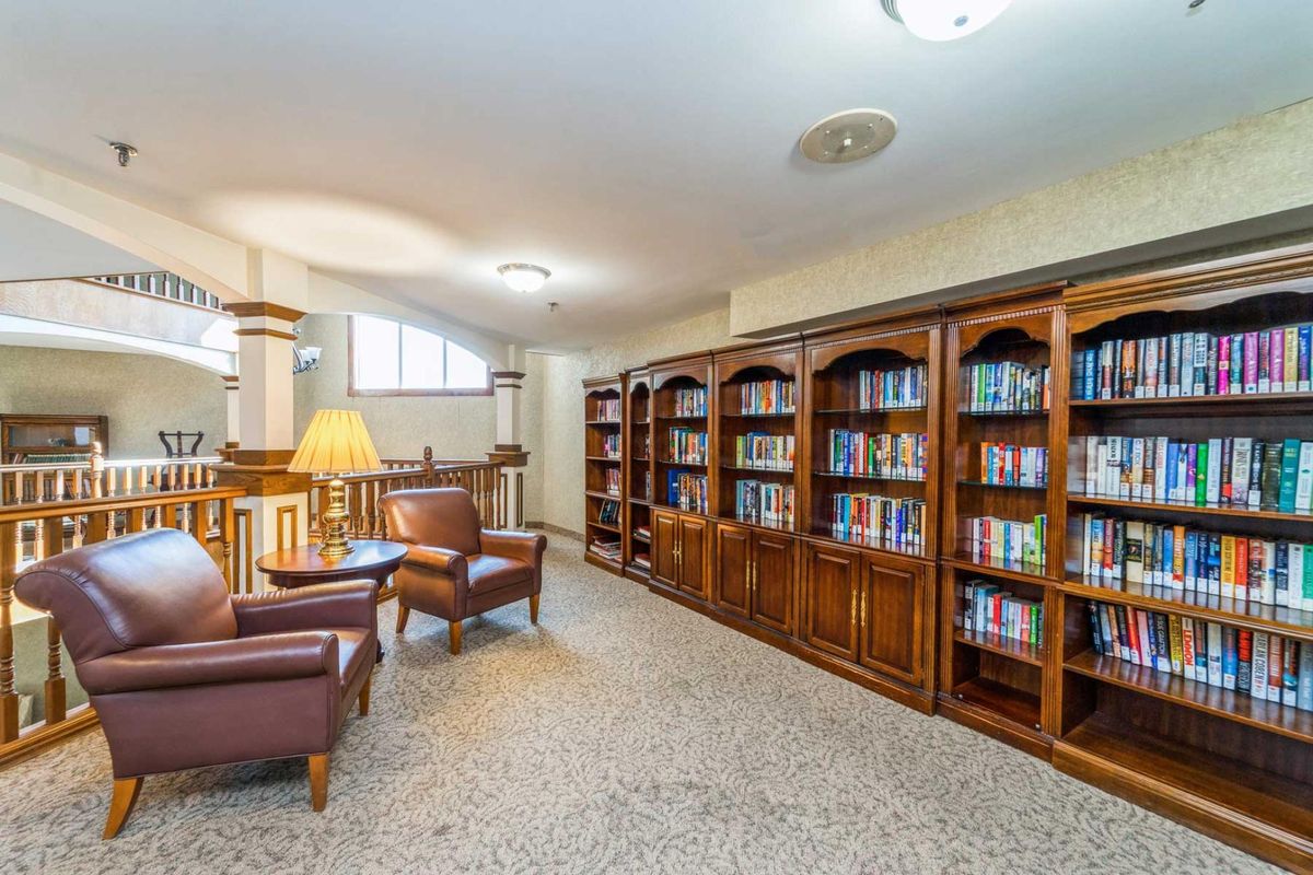 A cozy library with wooden bookshelves and comfortable armchairs.