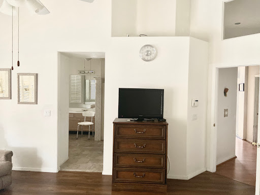 A modern living space featuring a wooden dresser and television against white walls.