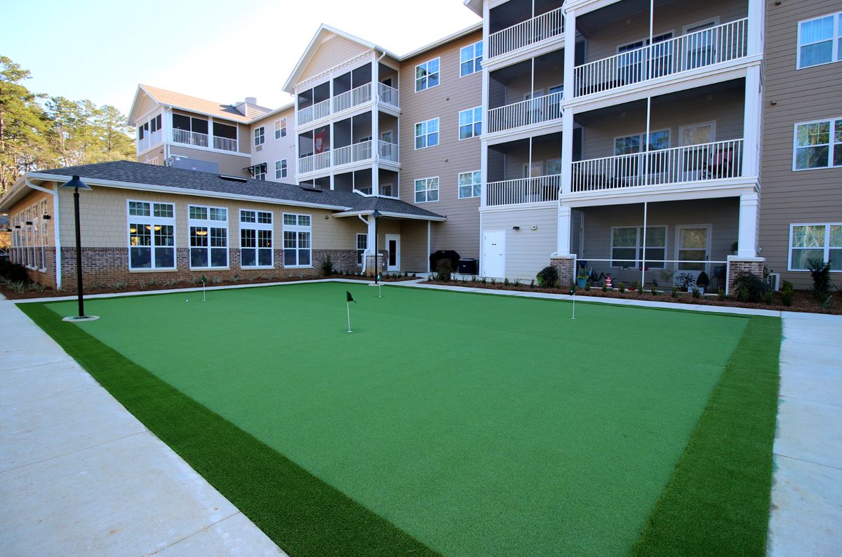 A modern apartment complex featuring spacious balconies and a well-maintained lawn area.