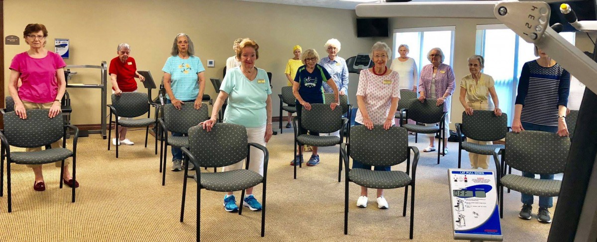 A group of seniors participating in a chair exercise class.