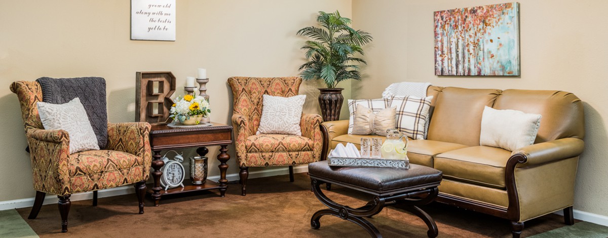 A cozy living room with an armchair, sofa, and decorative elements.