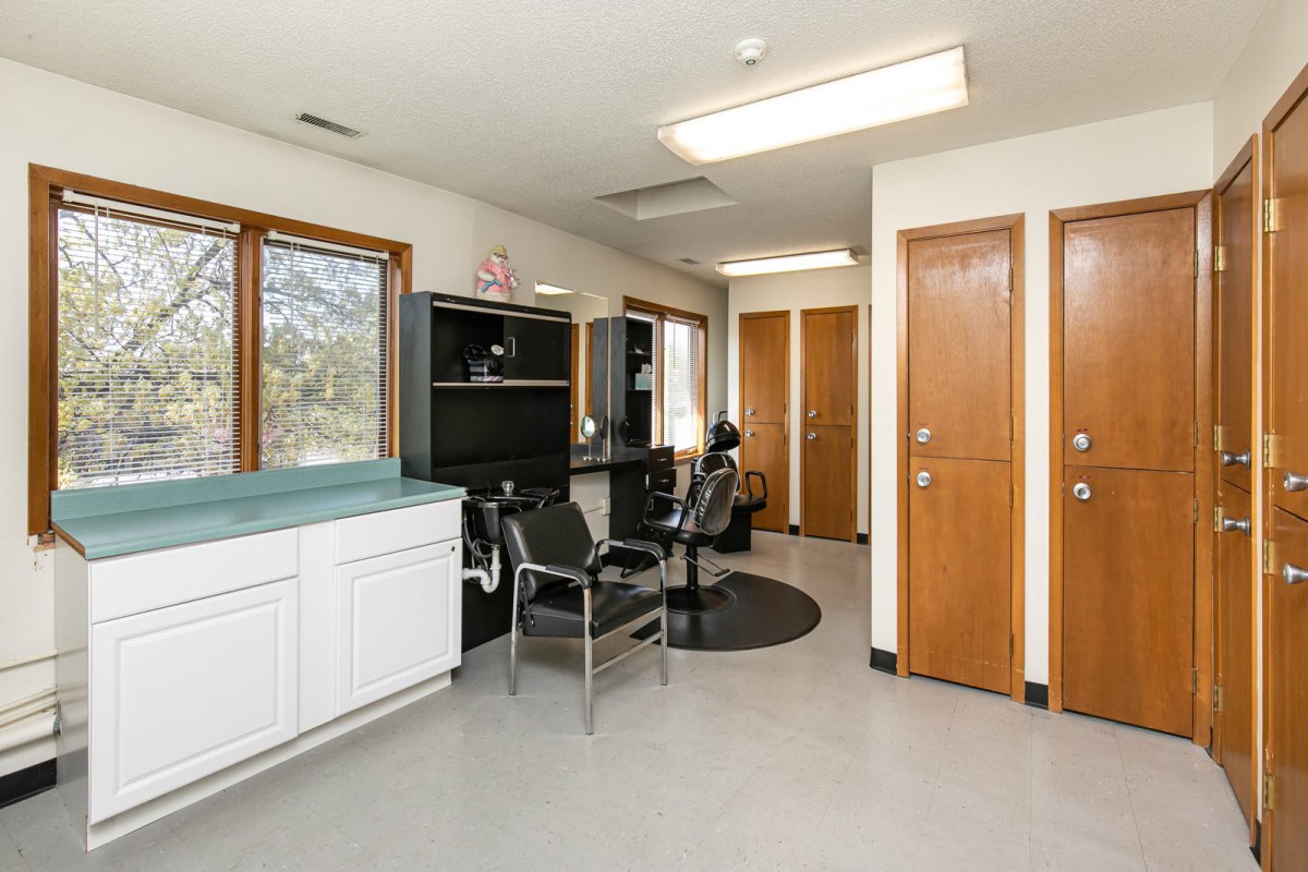 A brightly lit salon interior with styling chairs and mirrors.
