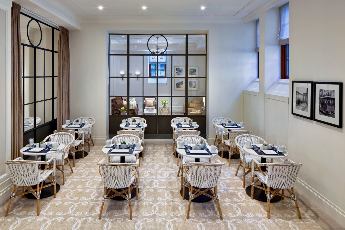 A modern dining area with neatly arranged tables and chairs, featuring elegant decor.