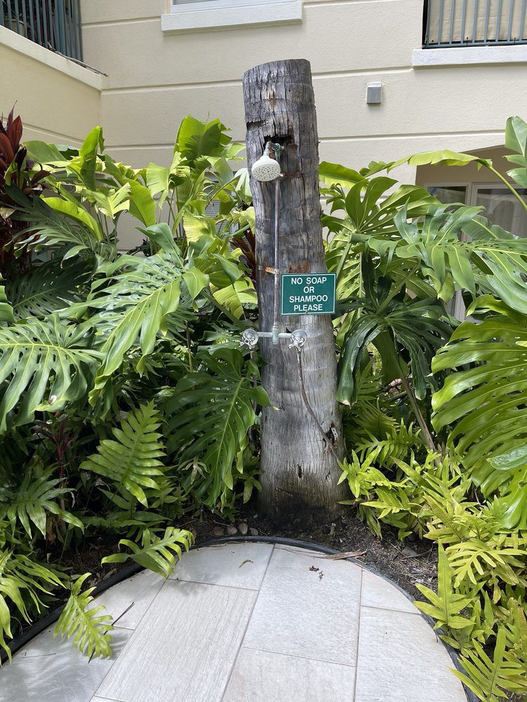 An outdoor shower surrounded by lush tropical plants.