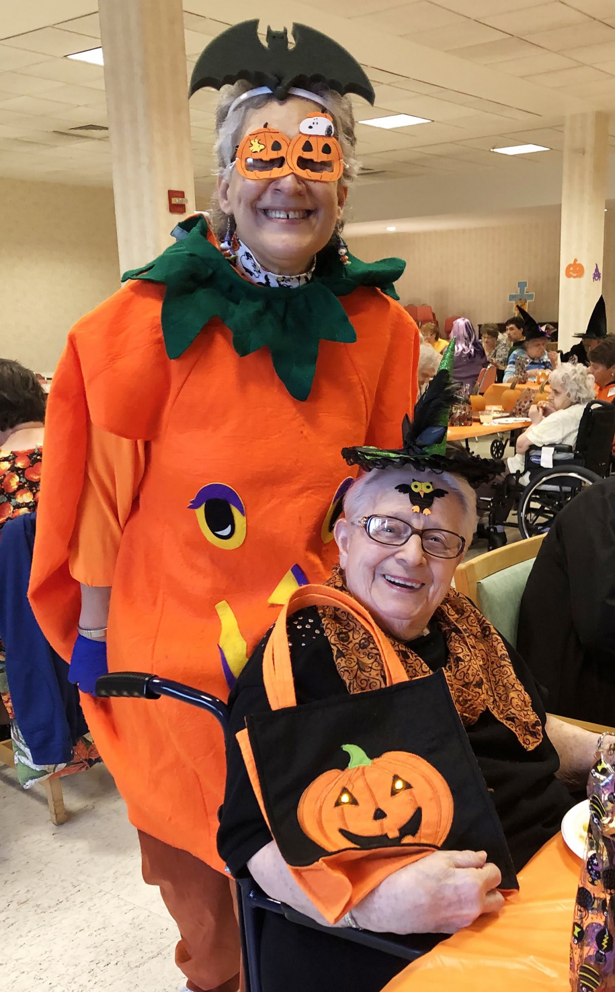 Two people dressed in pumpkin-themed costumes celebrating Halloween.