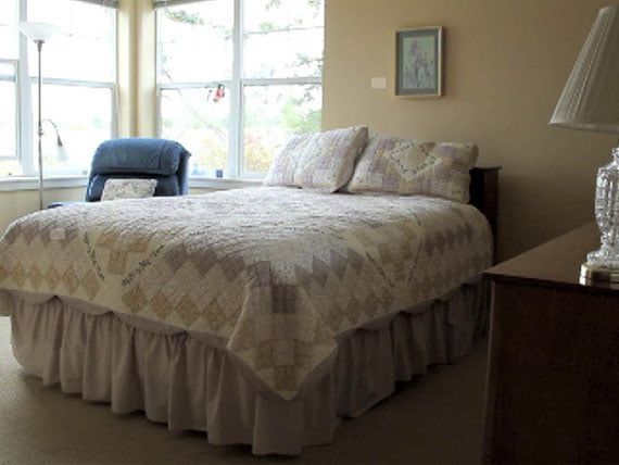 A cozy bedroom with a large bed and abundant natural light.