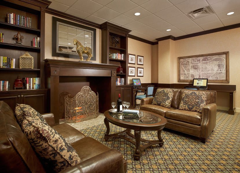 A cozy living room with leather furniture and a fireplace.