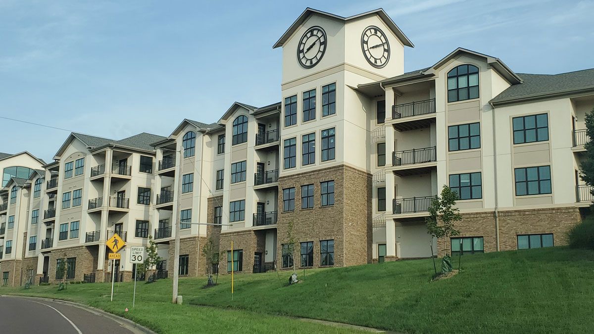 A modern residential apartment complex featuring a prominent clock tower.