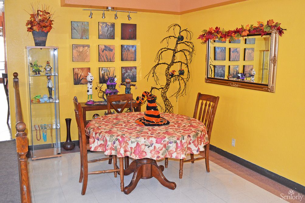 A cozy dining room decorated with Halloween and autumn-themed accents, featuring a table with a festive cloth and seasonal centerpiece.