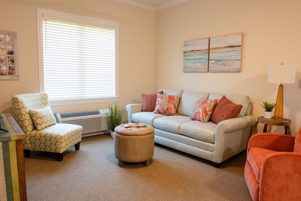 A cozy living room with a sofa, armchair, and decorative elements.