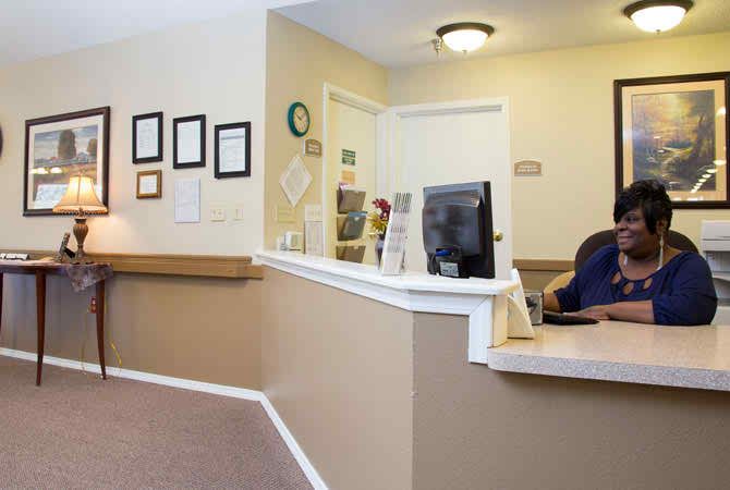 A reception area in an office setting with a desk and decorated walls.