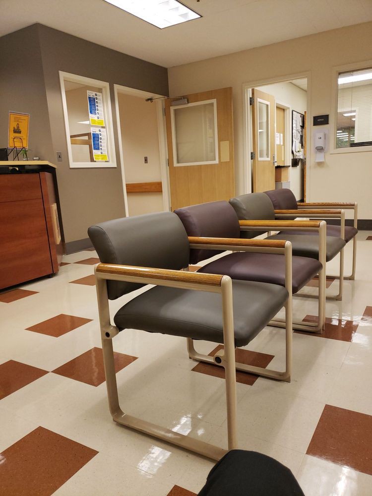 An empty waiting room in a hospital, with neatly arranged chairs and a clean, modern interior.