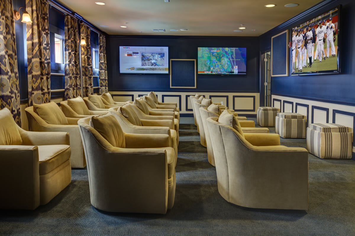 A luxurious lounge with comfortable seating and multiple television screens.