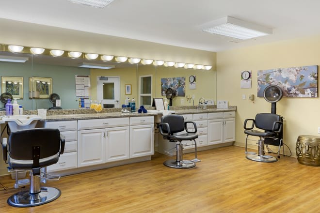 A hair salon interior with styling chairs, mirrors, and cabinets.