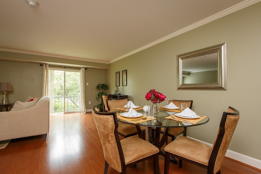 A stylish dining room featuring a round table set for a meal, complemented by elegant decor and natural light.