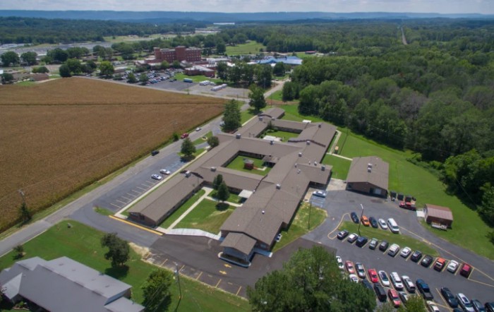 Aerial view of a school campus with surrounding fields and parking areas.