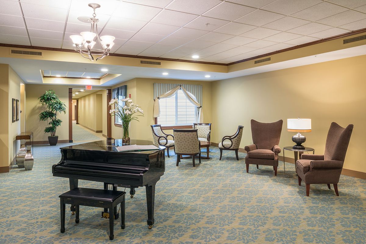 A well-appointed lobby with a grand piano, elegant seating, and soft lighting.