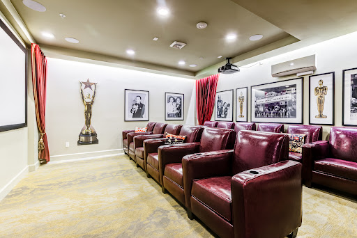 A stylish home theater featuring comfortable recliners and unique wall decorations.