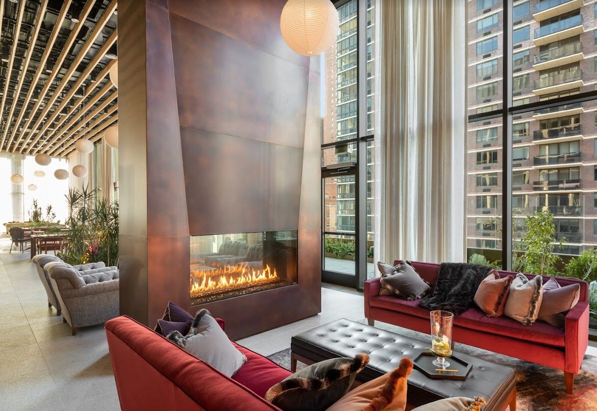 A luxurious modern living room with a sleek fireplace and large windows overlooking the city.