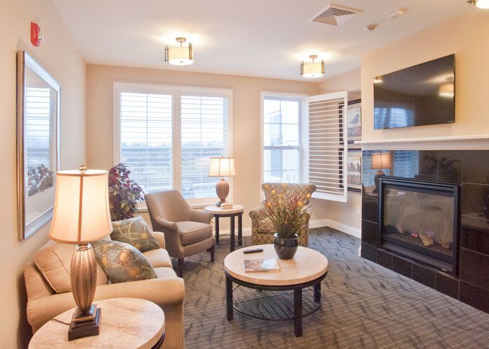 A cozy living room with comfortable seating, warm lighting, and a fireplace.