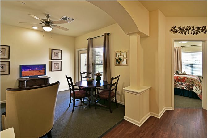 A cozy dining area with a round table and chairs, accented by warm lighting and elegant decor.