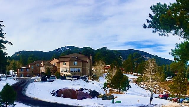 A snowy neighborhood with houses nestled in a mountainous landscape.