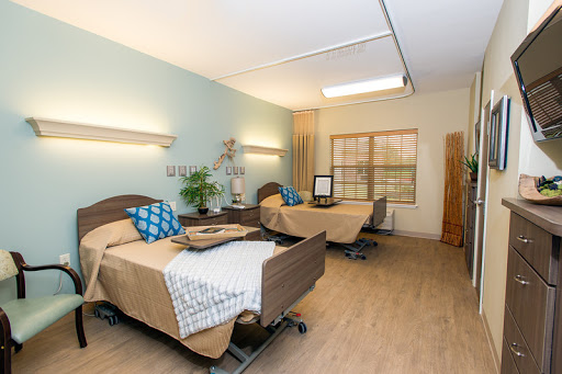A well-lit hospital room with two patient beds, designed for comfort and care.