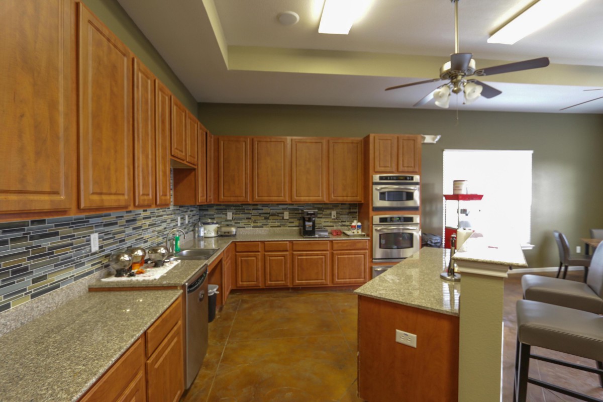 A spacious kitchen with wooden cabinets and modern appliances.