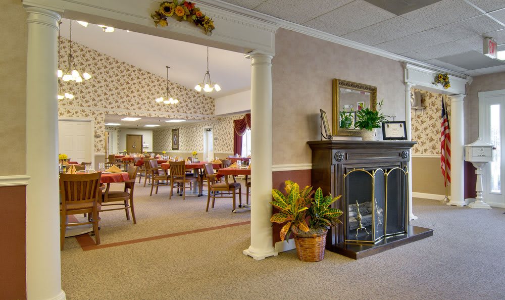 A warmly decorated dining area with a fireplace and seating for guests.