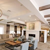 A modern living room with elegant furniture and a central fireplace.