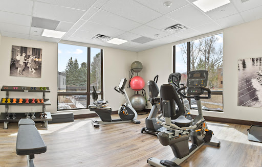 A bright and modern gym space featuring various exercise equipment, designed for fitness enthusiasts.